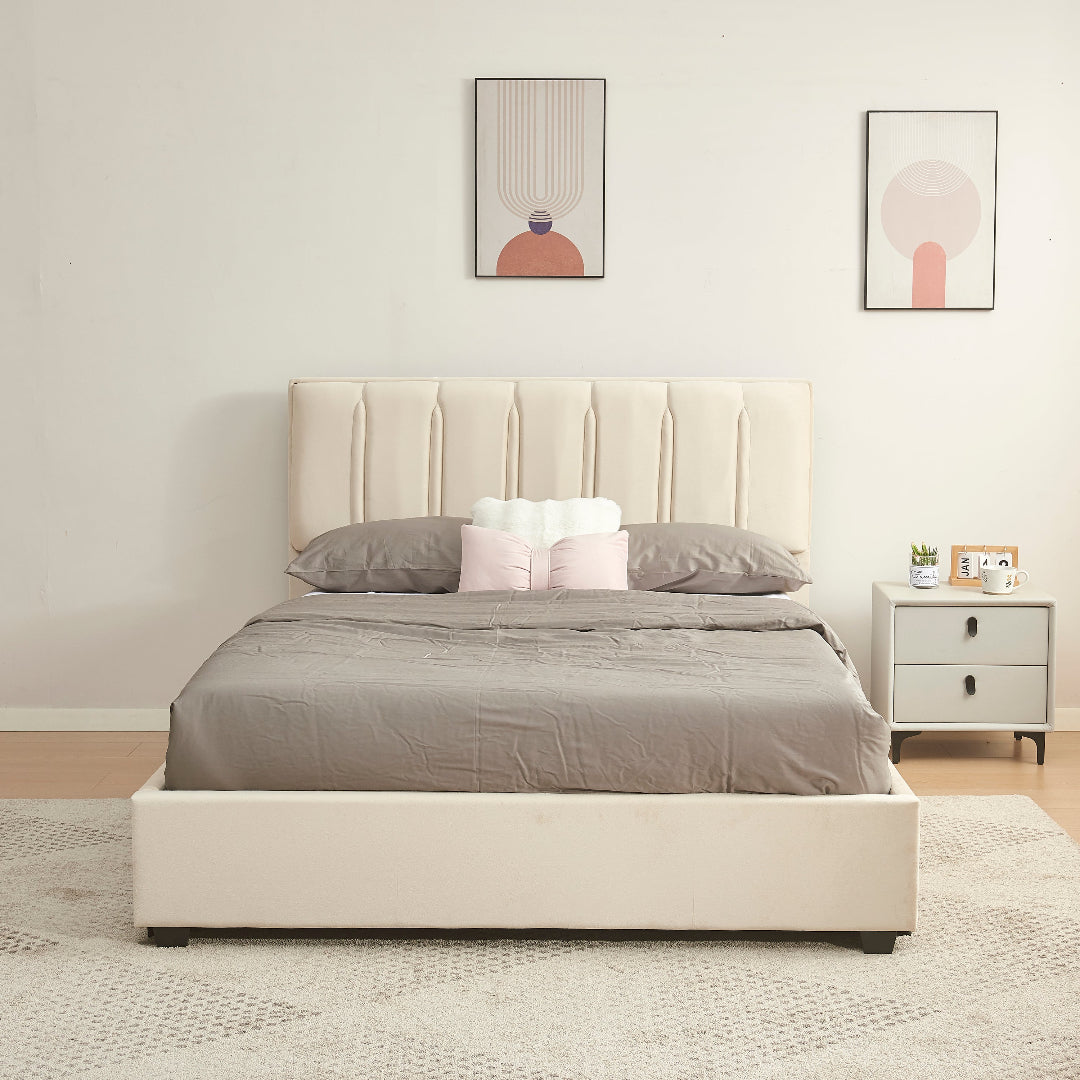 Beige upholstered bed with gray bedding in a bedroom setting.