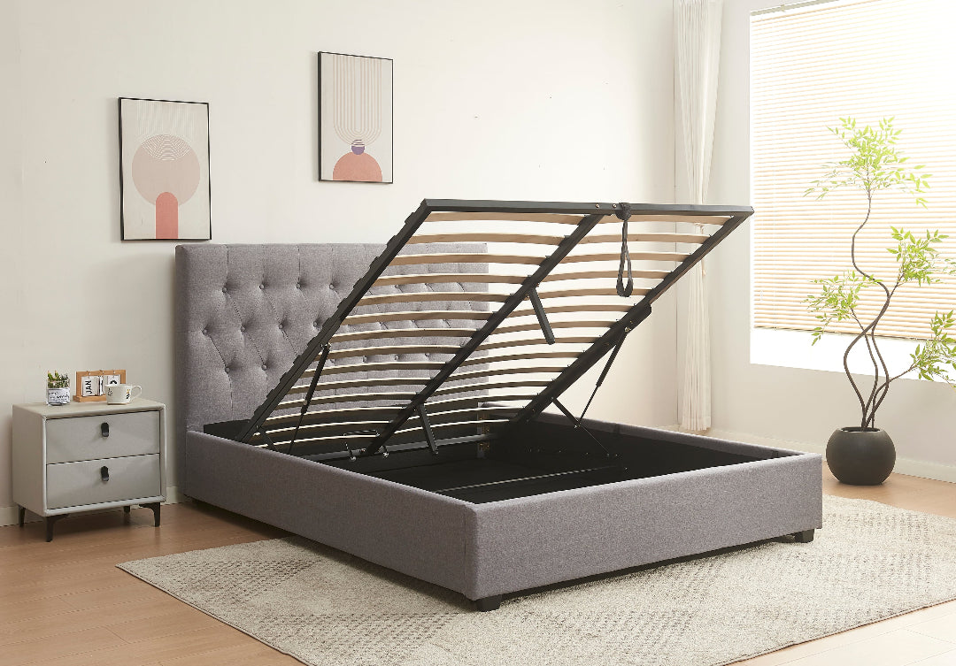 Gray upholstered bed with black metal frame in a bedroom setting.
