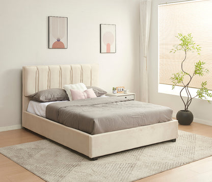 Beige upholstered bed with gray bedding in a room with a window and plant.