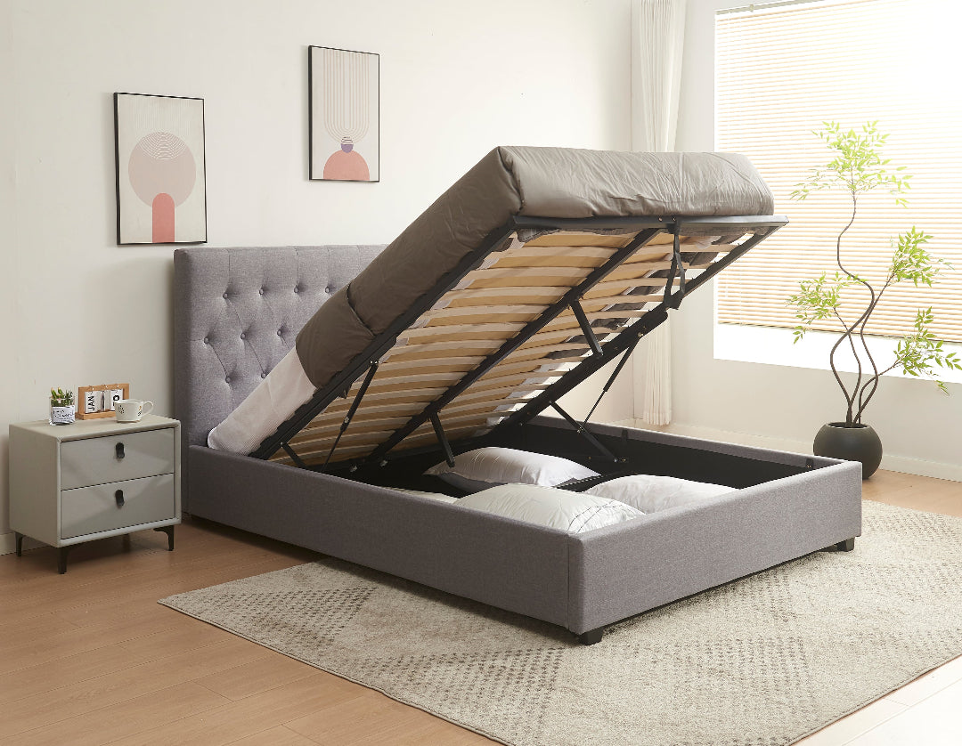 Gray upholstered bed with raised headboard in a bedroom setting.